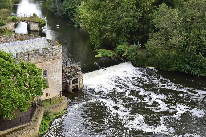 The old mill and engine house beside the weir on the River Avon