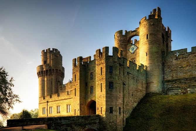 The east front of Warwick Castle lit low and warm at sunset